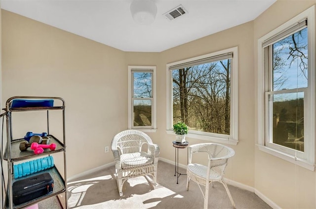 living area with visible vents, a healthy amount of sunlight, and carpet floors