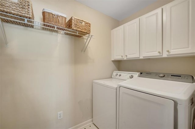 laundry room with washer and dryer, baseboards, and cabinet space