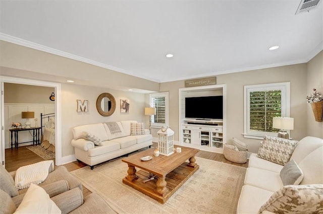 living area featuring visible vents, ornamental molding, wood finished floors, recessed lighting, and baseboards