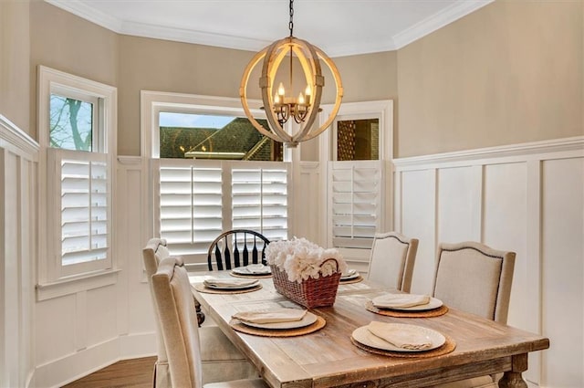 dining room featuring crown molding, a decorative wall, and a notable chandelier