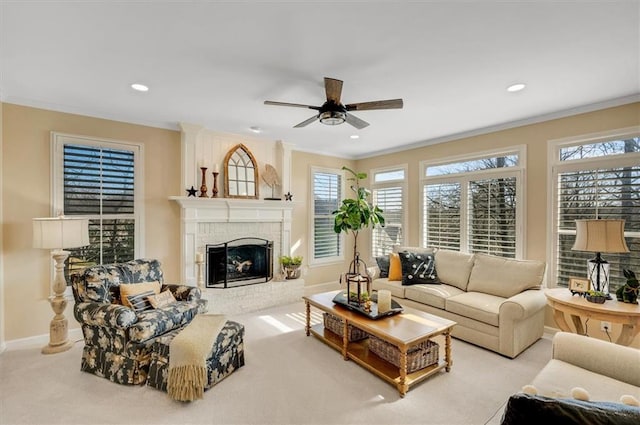 carpeted living room featuring baseboards, recessed lighting, ceiling fan, crown molding, and a brick fireplace