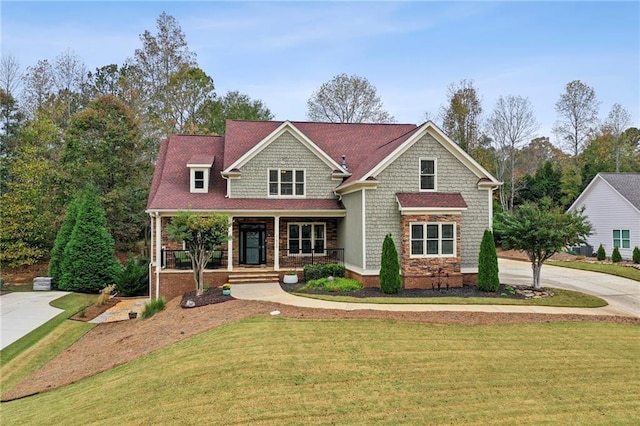 view of front of home with covered porch and a front lawn