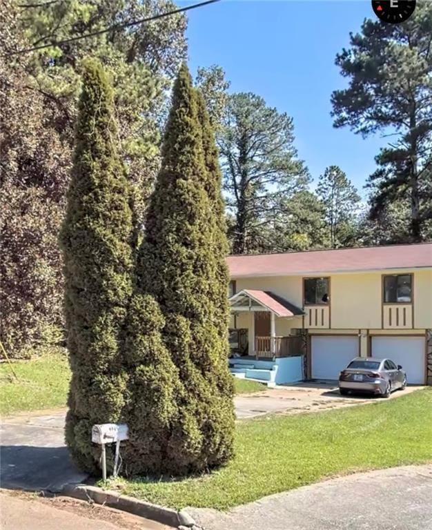 view of front of house with an attached garage, driveway, and stucco siding
