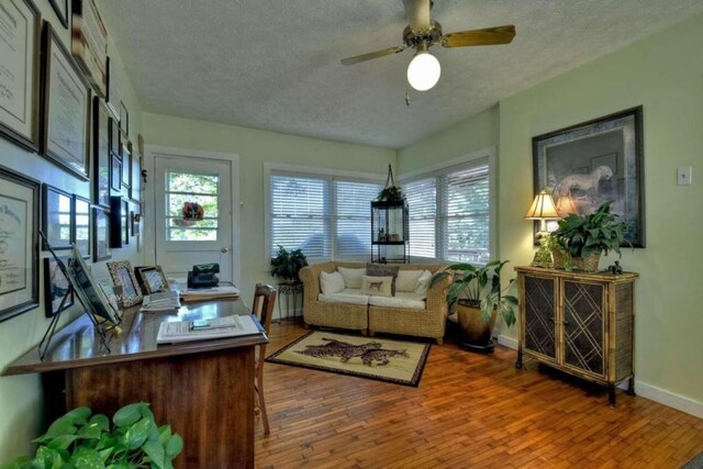 interior space featuring a textured ceiling, hardwood / wood-style flooring, and ceiling fan