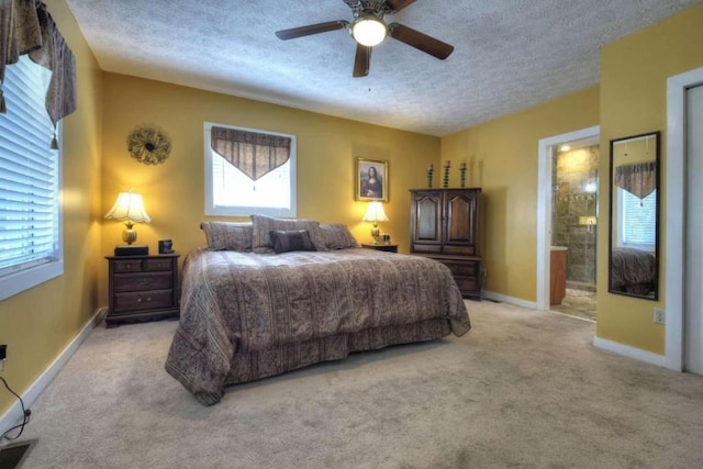 carpeted bedroom with connected bathroom, ceiling fan, a textured ceiling, and multiple windows