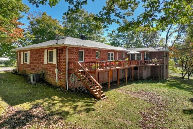 back of property with a yard, a deck, and central air condition unit