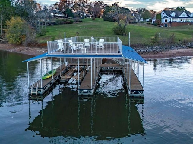 view of dock featuring a lawn, a water view, and boat lift