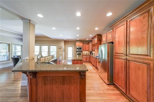 kitchen with ornamental molding, sink, light hardwood / wood-style flooring, and stainless steel appliances