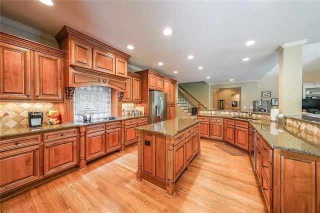 kitchen featuring ornamental molding, stainless steel fridge, kitchen peninsula, and light hardwood / wood-style floors