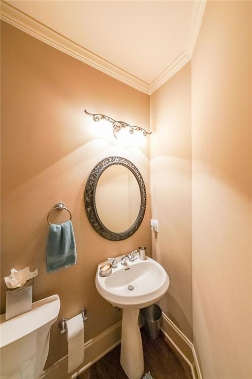 bathroom featuring toilet, ornamental molding, and hardwood / wood-style floors