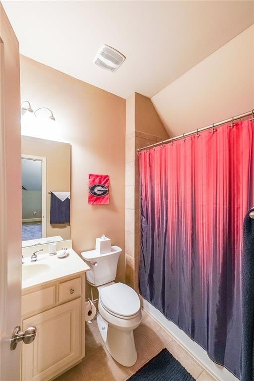 bathroom featuring toilet, tile patterned floors, lofted ceiling, walk in shower, and vanity