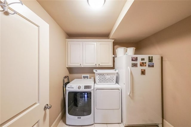 washroom with washer and dryer, cabinets, and light tile patterned floors