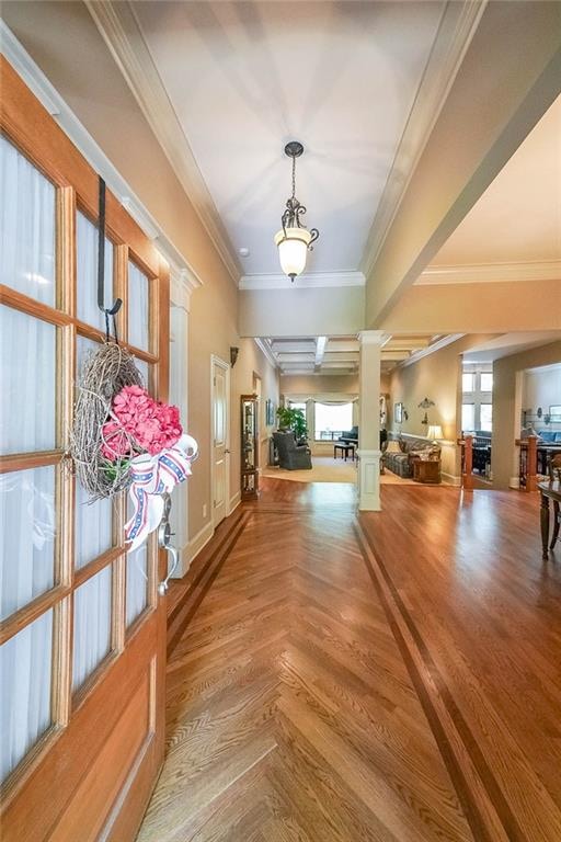 hallway featuring crown molding and decorative columns