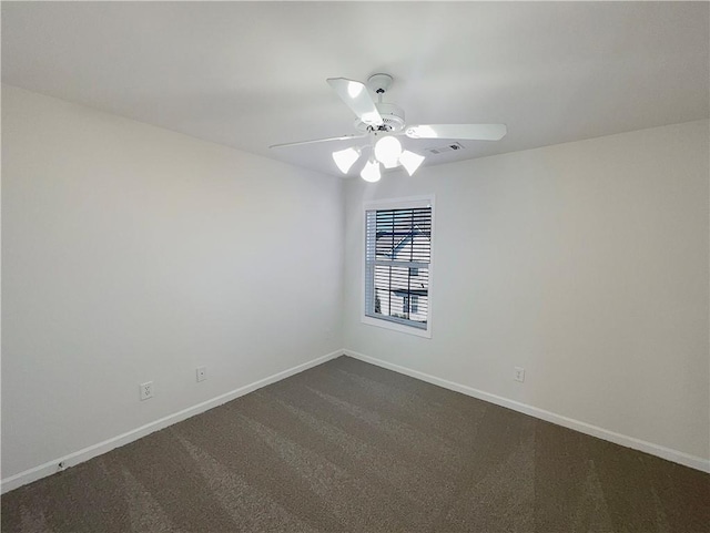 unfurnished room featuring a ceiling fan, dark colored carpet, visible vents, and baseboards