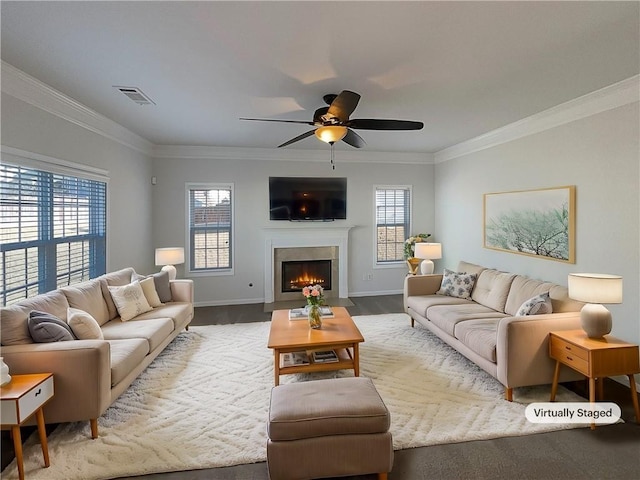 living area with a fireplace with flush hearth, visible vents, ornamental molding, and baseboards