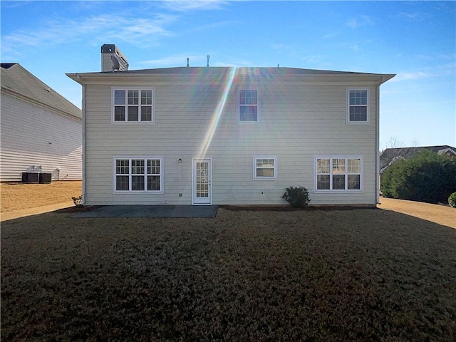 back of house with a patio area, a yard, a chimney, and central AC unit