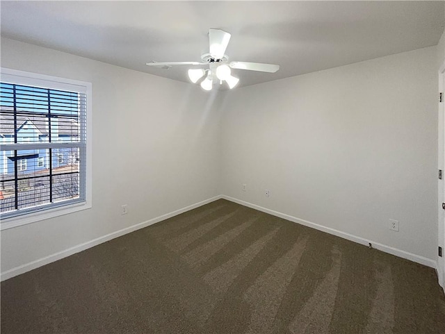 unfurnished room featuring a ceiling fan, dark colored carpet, and baseboards