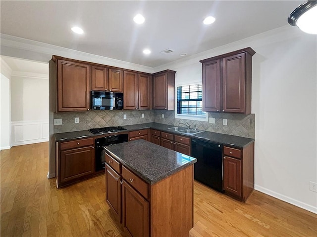 kitchen with black appliances, ornamental molding, a sink, and light wood-style flooring