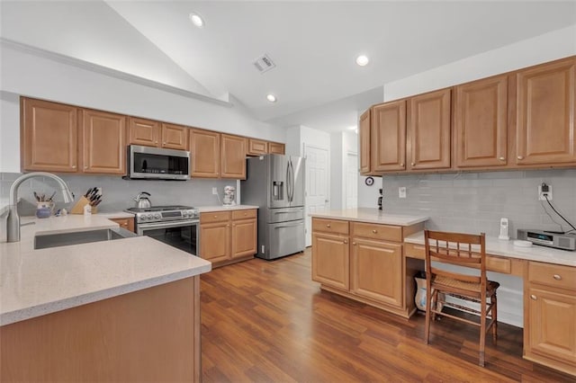 1402 Silver Summit Dr SE, Conyers, GA 30094 - kitchen with stainless steel appliances, built in desk, vaulted ceiling, tasteful backsplash, and dark wood-style flooring
