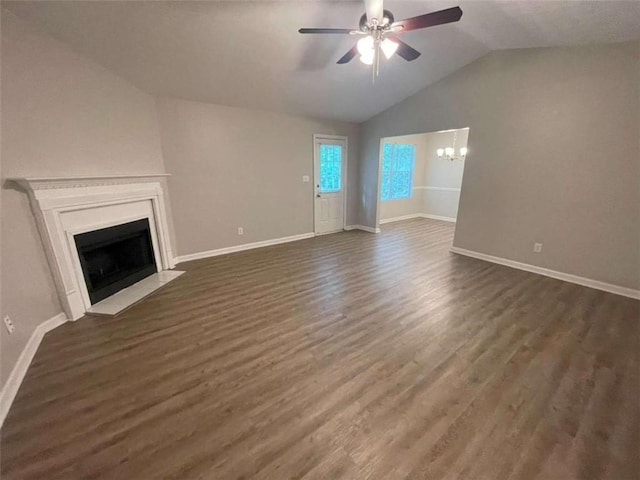 unfurnished living room with ceiling fan with notable chandelier, dark hardwood / wood-style floors, and lofted ceiling