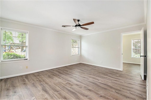 empty room with crown molding, baseboards, wood finished floors, and ceiling fan