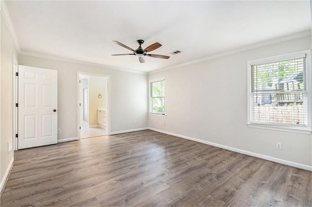 unfurnished bedroom with ornamental molding, wood finished floors, baseboards, ensuite bath, and a ceiling fan
