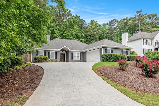 ranch-style home featuring a chimney, an attached garage, driveway, and fence