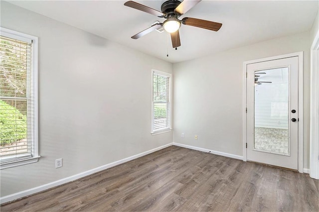 unfurnished room with wood finished floors, baseboards, and a ceiling fan