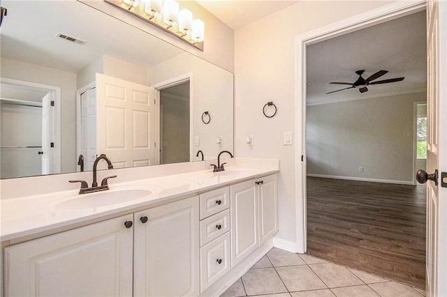 bathroom featuring ceiling fan, tile patterned flooring, double vanity, and baseboards