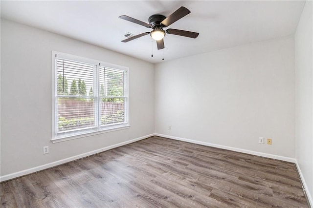 empty room featuring wood finished floors, ceiling fan, and baseboards