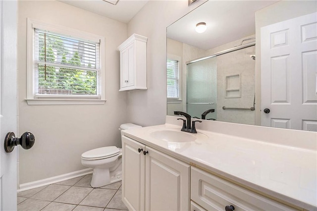 bathroom featuring toilet, a stall shower, baseboards, vanity, and tile patterned flooring