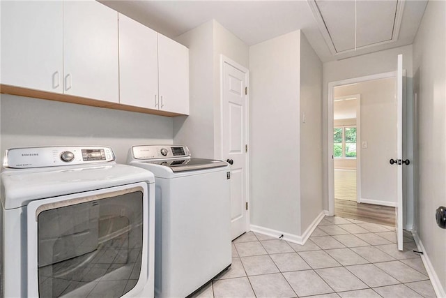 laundry room featuring attic access, cabinet space, baseboards, and independent washer and dryer