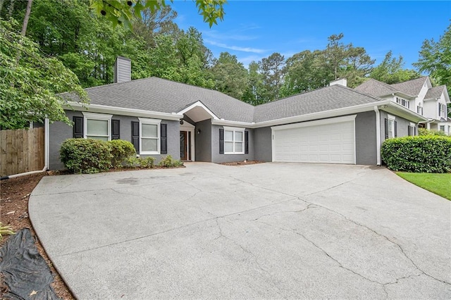 ranch-style house with a chimney, a garage, driveway, fence, and stucco siding