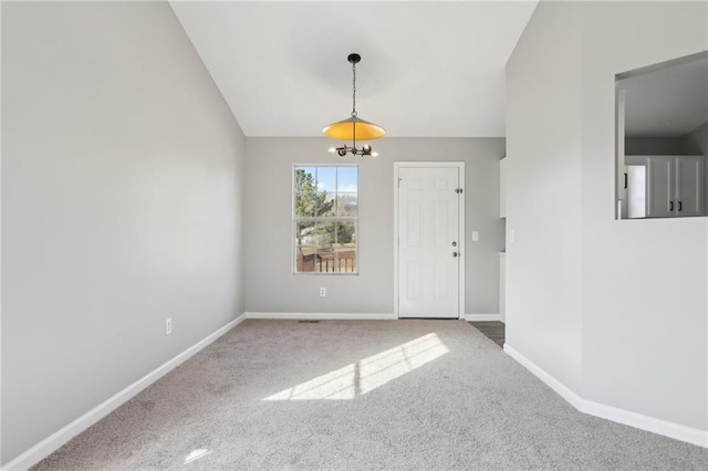 carpeted empty room featuring a chandelier and lofted ceiling