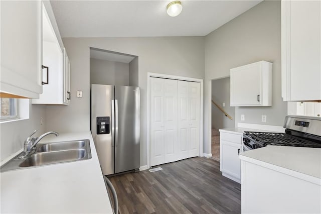 kitchen featuring white cabinetry, sink, dark hardwood / wood-style floors, lofted ceiling, and appliances with stainless steel finishes