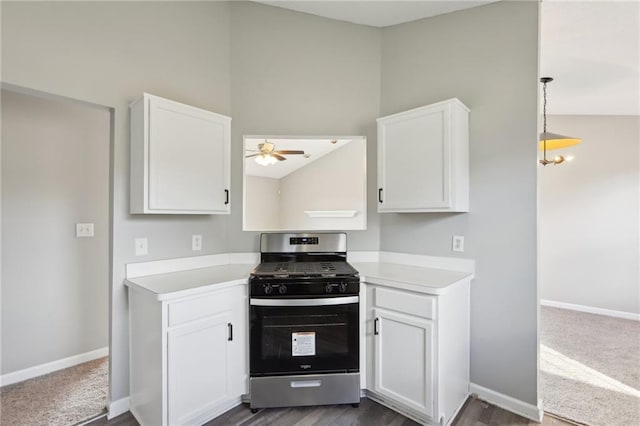 kitchen featuring gas stove, ceiling fan with notable chandelier, vaulted ceiling, pendant lighting, and white cabinets