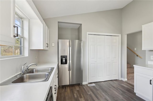 kitchen featuring appliances with stainless steel finishes, dark hardwood / wood-style flooring, sink, white cabinets, and lofted ceiling