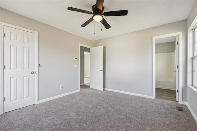 unfurnished bedroom with carpet floors, ensuite bathroom, and ceiling fan