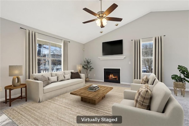 carpeted living room with ceiling fan, lofted ceiling, and a wealth of natural light