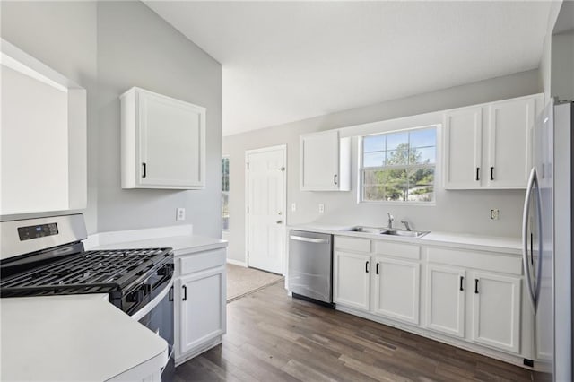 kitchen with sink, dark hardwood / wood-style flooring, vaulted ceiling, white cabinets, and appliances with stainless steel finishes