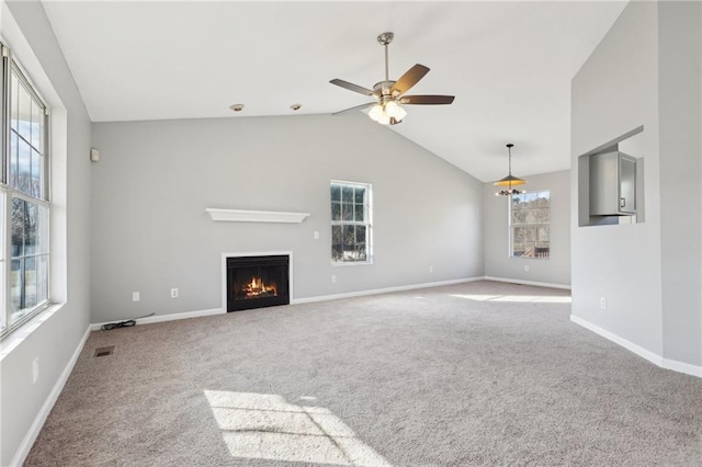 unfurnished living room with ceiling fan, carpet floors, and vaulted ceiling