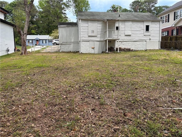 rear view of property with a lawn, crawl space, and fence
