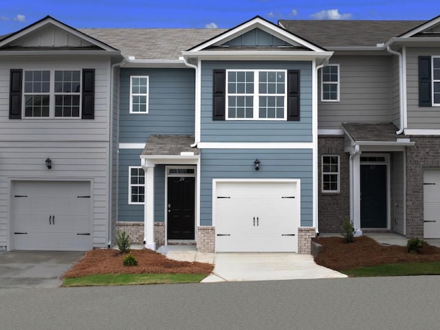 townhome / multi-family property featuring a garage, board and batten siding, and brick siding