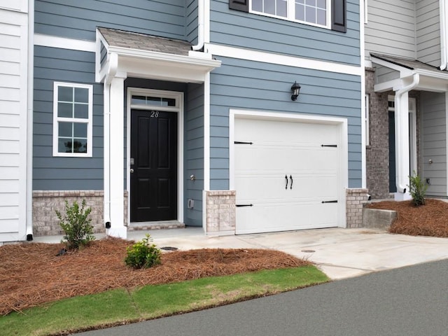 property entrance featuring a garage and roof with shingles