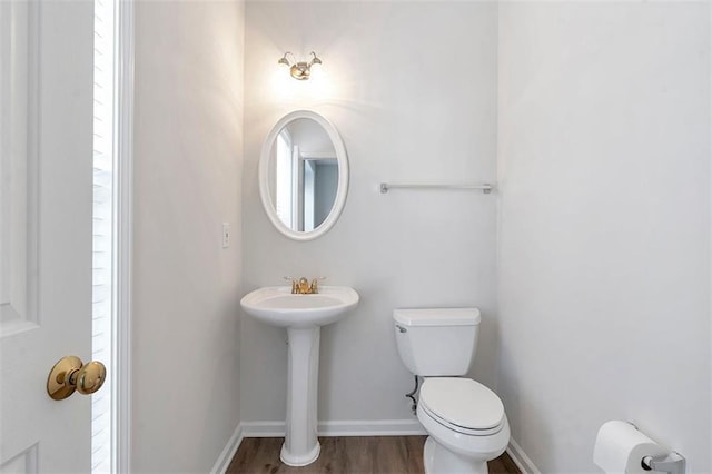 bathroom featuring toilet, baseboards, and wood finished floors