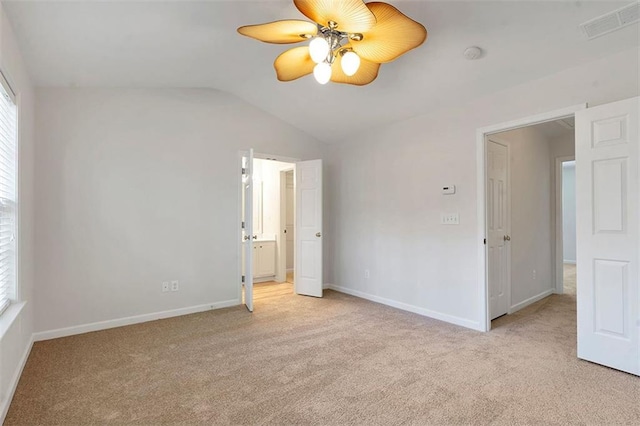 unfurnished bedroom featuring visible vents, baseboards, carpet flooring, and vaulted ceiling