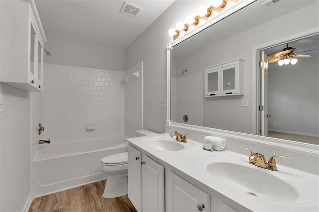 bathroom with toilet, a ceiling fan, visible vents, and a sink