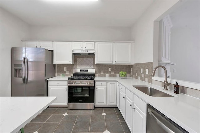 kitchen featuring a sink, stainless steel appliances, tasteful backsplash, and white cabinets