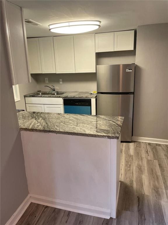 1150 Rankin St Unit D1, Stone Mountain, GA 30083 - kitchen with freestanding refrigerator, dishwasher, white cabinets, and stone countertops
