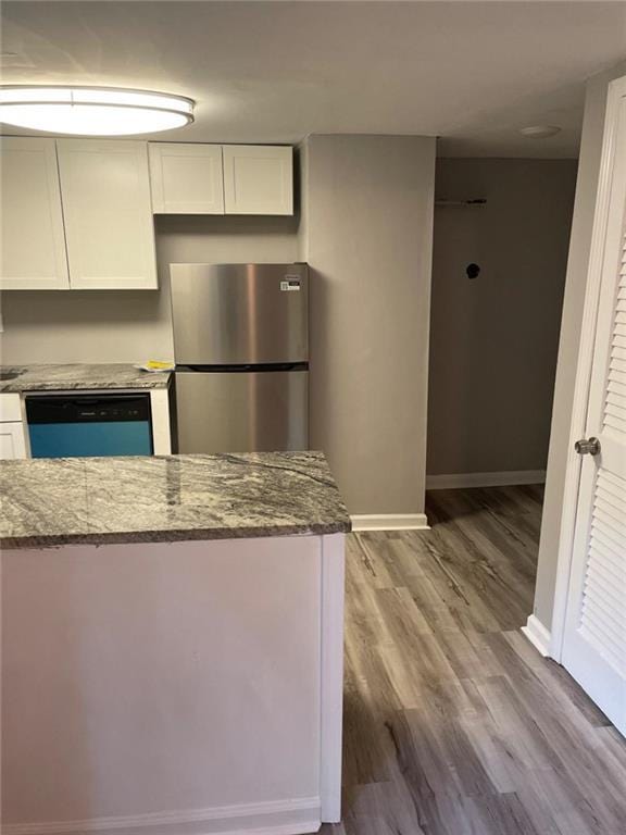 1150 Rankin St Unit D1, Stone Mountain, GA 30083 - kitchen with freestanding refrigerator, dishwasher, dark stone counters, and white cabinetry